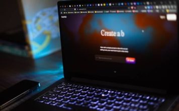 What Is Suno AI? The Music Generator Making Waves image of a laptop with Suno AI logo on the screen