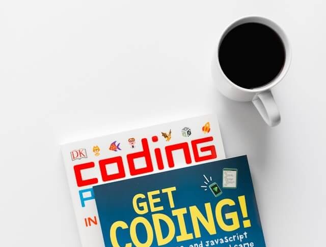 an image of a coding book with a coffee next to it, the Coding Challenges for Beginners